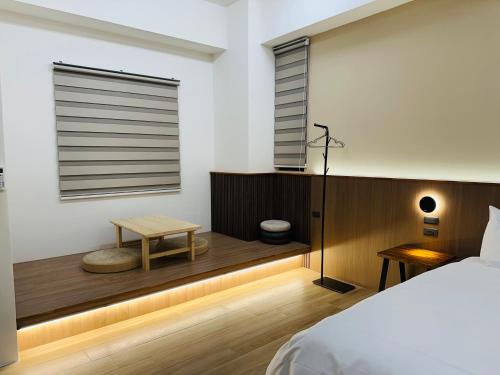 a bedroom with a bed and a table and a window at 穗眠民宿SnoozeInn in Chishang