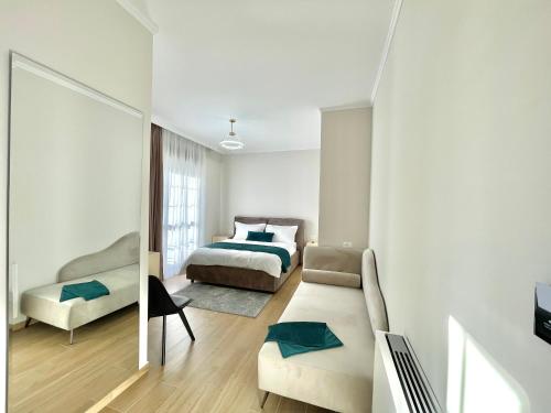 a white bedroom with a bed and a couch at Villa Safira in Durrës