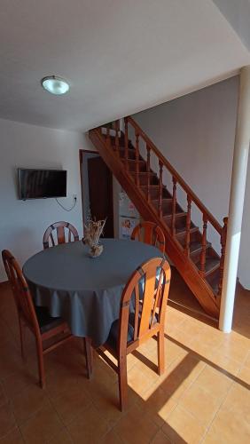 a dining room with a table and chairs and a staircase at Excelente Departamento en Calle 44 - Deptos Apolo in Las Toninas
