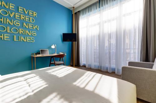 a bedroom with a bed and a blue wall at Colors Urban Hotel Thessaloniki in Thessaloniki