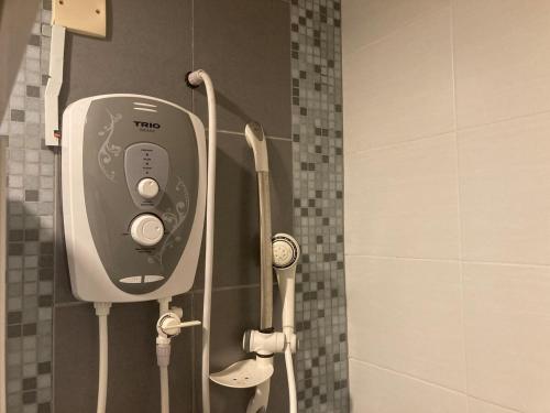 a soap dispenser on the wall of a shower at UrbaNest in Kota Bharu