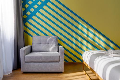 a chair in a room with a striped wall at Colors Urban Hotel Thessaloniki in Thessaloniki
