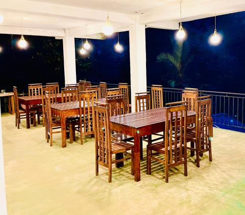 ein Esszimmer mit Holztischen und Stühlen in der Unterkunft Ranmudu Hotel in Hanwella