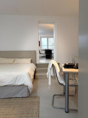 a bedroom with a bed and a table and a mirror at Modern, bright apartment for individuals & groups in Remscheid