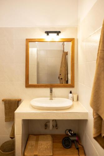 a bathroom with a sink and a mirror at OMNYA Nungwi Boutique Hotel in Nungwi