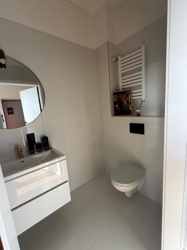 a white bathroom with a toilet and a mirror at Apartament SLEEP&GO Ostrowiec Świętokrzyski in Ostrowiec Świętokrzyski