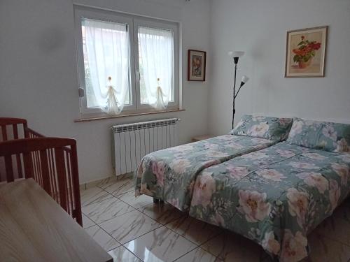 a bedroom with a bed and a table and windows at Villa Azzurra in Monfalcone