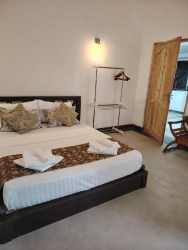 a bedroom with a large bed with two pillows on it at Charlotte Inn in Kandy