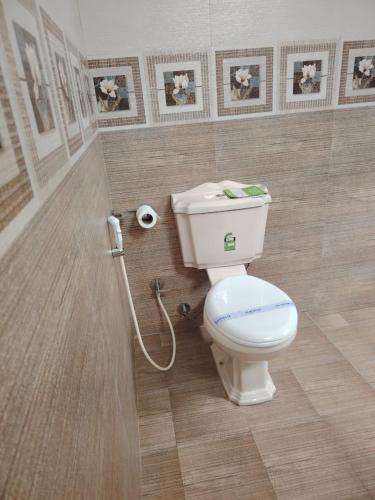 a bathroom with a toilet and a roll of toilet paper at Charlotte Inn in Kandy