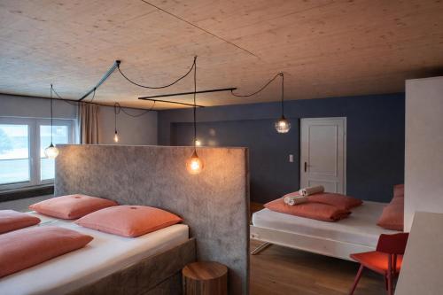 a bedroom with two beds with orange pillows at Stadtappartement Saalfelden in Saalfelden am Steinernen Meer