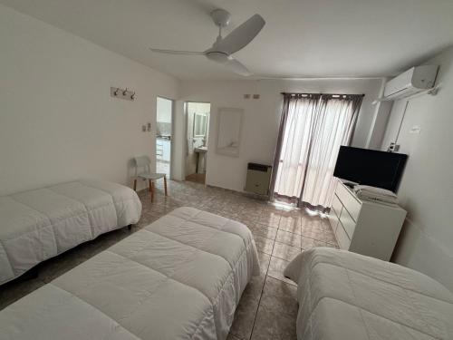 a hotel room with two beds and a flat screen tv at Apart Hotel ONCATIVO in Oncativo
