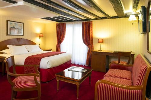 パリにあるホテル アンペリアル パリのベッド、テーブル、椅子が備わるホテルルームです。