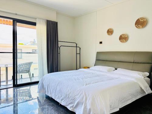 a bedroom with a large white bed and a balcony at West14 Tamarin Bay,Studio in Tamarin