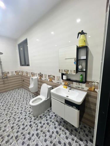 a bathroom with a white toilet and a sink at 44 đặng dung in Buon Ma Thuot