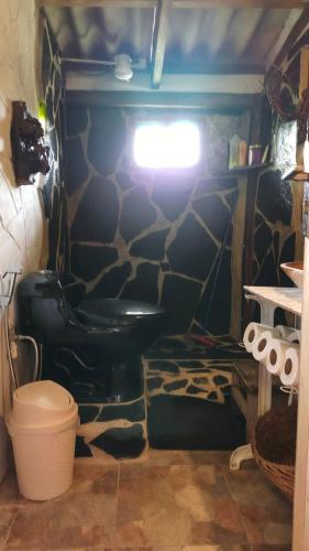 un bagno con un water nero in una stanza di Cabaña Renacer a Samaipata