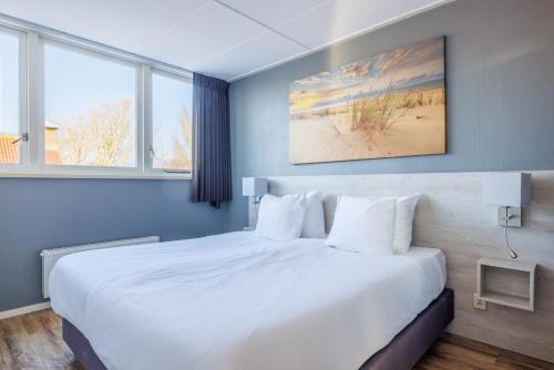 a bedroom with a large bed with white pillows at Zilt in Hollum