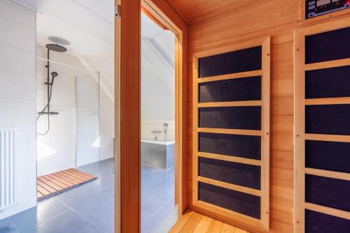 a bathroom with a shower and a glass door at Zilt in Hollum