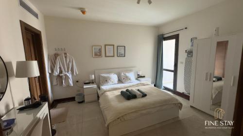 a white bedroom with a bed and a bathroom at Modern 2BR Duplex in New Cairo Quiet Area, Balcony & Fast WiFi in Cairo