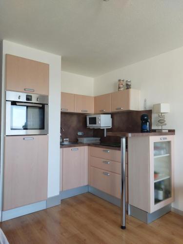 an empty kitchen with a counter and a microwave at Le Grand Large in Gruissan