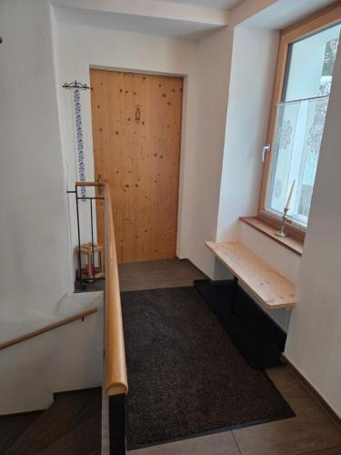a room with a wooden door and a wooden bench at Chasa Bellavista in Ardez