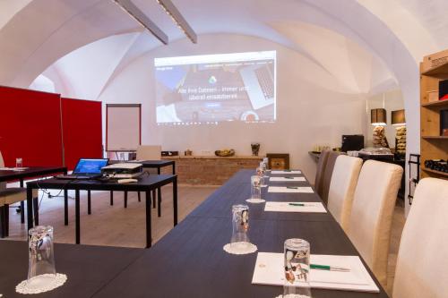 a conference room with tables and a projection screen at Hotel Landhaus Moserhof in Gumpoldskirchen
