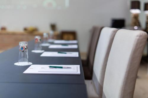 a row of tables with glasses and pens on them at Hotel Landhaus Moserhof in Gumpoldskirchen