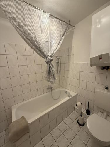 a bathroom with a tub and a toilet and a sink at Apartment Kompakt Gottschalk 5,0 in Kassel