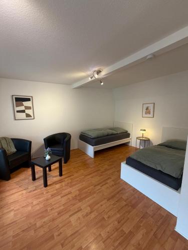 a room with two beds and a couch and a table at Apartment Kompakt Gottschalk 5,0 in Kassel
