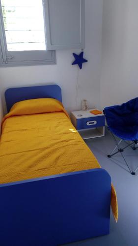 a bedroom with a blue bed and a blue chair at Buonavacanza in Erice