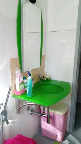 a green sink in a bathroom with a mirror at Buonavacanza in Erice