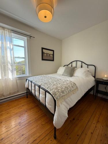 a bedroom with a bed in a room with a window at Little Banook B&B in Halifax