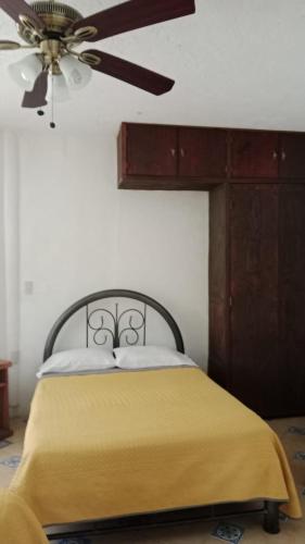 a bedroom with a bed with a ceiling fan at Quinta Corona Hospedaje Familiar in Oaxtepec