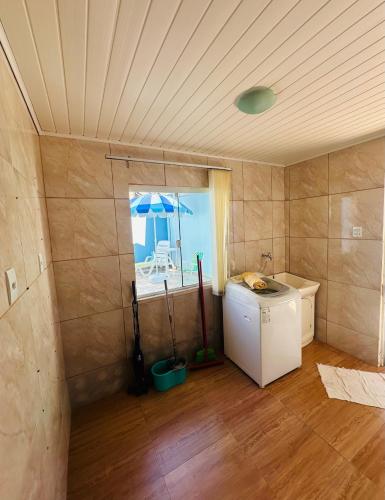 a laundry room with a refrigerator and an umbrella at casapraia penha sc in Penha