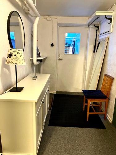 a bathroom with a sink and a mirror and a chair at Nordic Quiet Stay in Falun