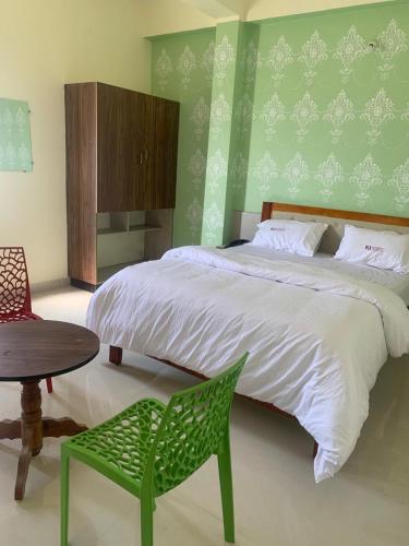 a bedroom with a bed and a table and a chair at KH Residency And Lodging in Punganūru
