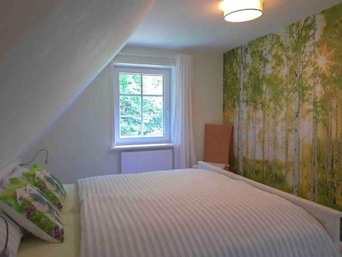a small bedroom with a bed and a window at Ferienwohnung am Eichenpark, Lüneburger Heide in Egestorf