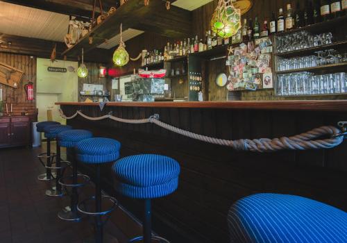 een rij blauwe krukken in een bar bij Hotel Restaurant Seestern in Heiligenhafen
