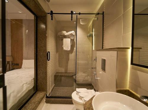 a bathroom with a shower and a toilet and a sink at Gold's Pyramids Hotel in Cairo