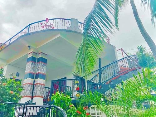 a house with a balcony and a staircase on it at Placido's Vacation Home in Puerto Galera
