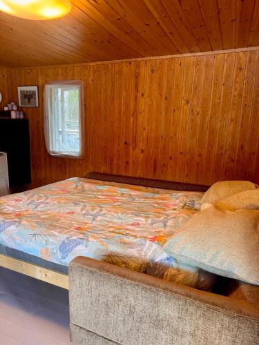 a bedroom with a bed in a wooden room at Nordic Experience Nuuksio Sauna in Nuuksio