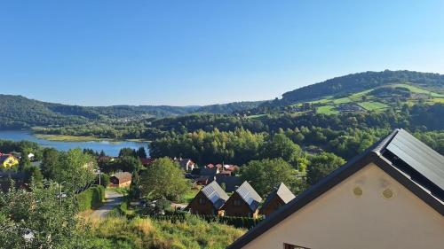 an aerial view of a village with a river and houses at Róża Wiatrów in Solina
