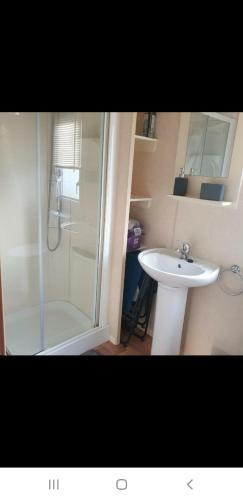a bathroom with a sink and a shower and a toilet at Rhyl, Wales, CHESTNUT GARDENS Cost road Rhyl in Meliden