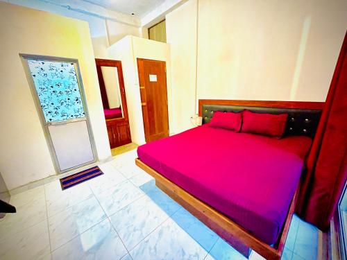 ein Schlafzimmer mit einem großen Bett und einer roten Decke in der Unterkunft Ranmudu Hotel in Hanwella