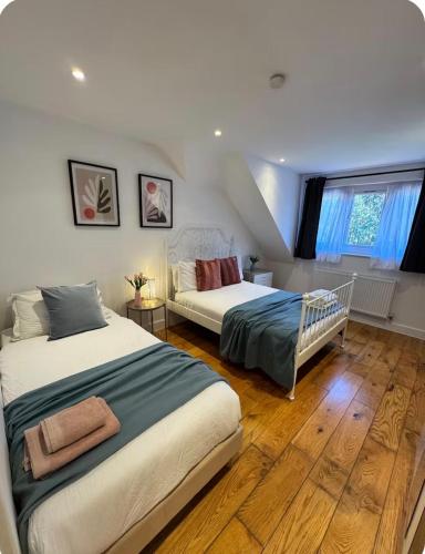 a bedroom with two beds and a window at En-suites with Free Parking, Wembley Park station and stadium in London