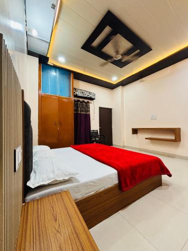 a bedroom with a large bed with a red blanket at Grihalaxmi Paying Guest House in Varanasi