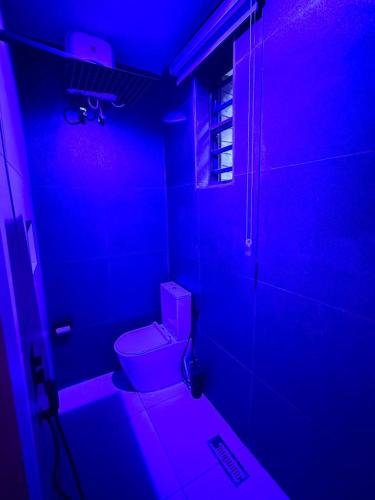 a bathroom with a toilet in a purple light at Cosmos in Lagos