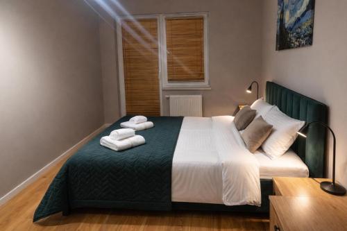 a bedroom with a bed with towels on it at MODERN APARTAMENT Walendów Park in Walendów