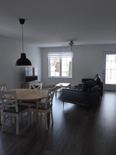 a living room with a table and a couch at Appartement de 2 chambre à la baie in Saguenay