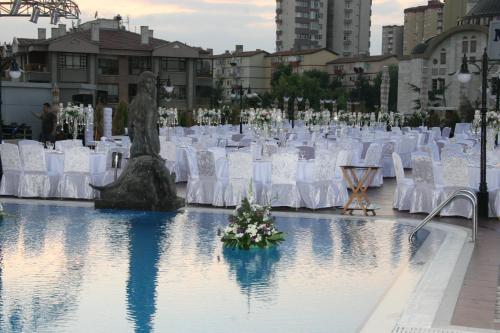 a wedding venue with white chairs and tables at Buyukhanli Park Hotel in Ankara