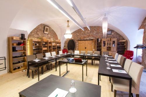 a restaurant with tables and chairs in a room at Hotel Landhaus Moserhof in Gumpoldskirchen
